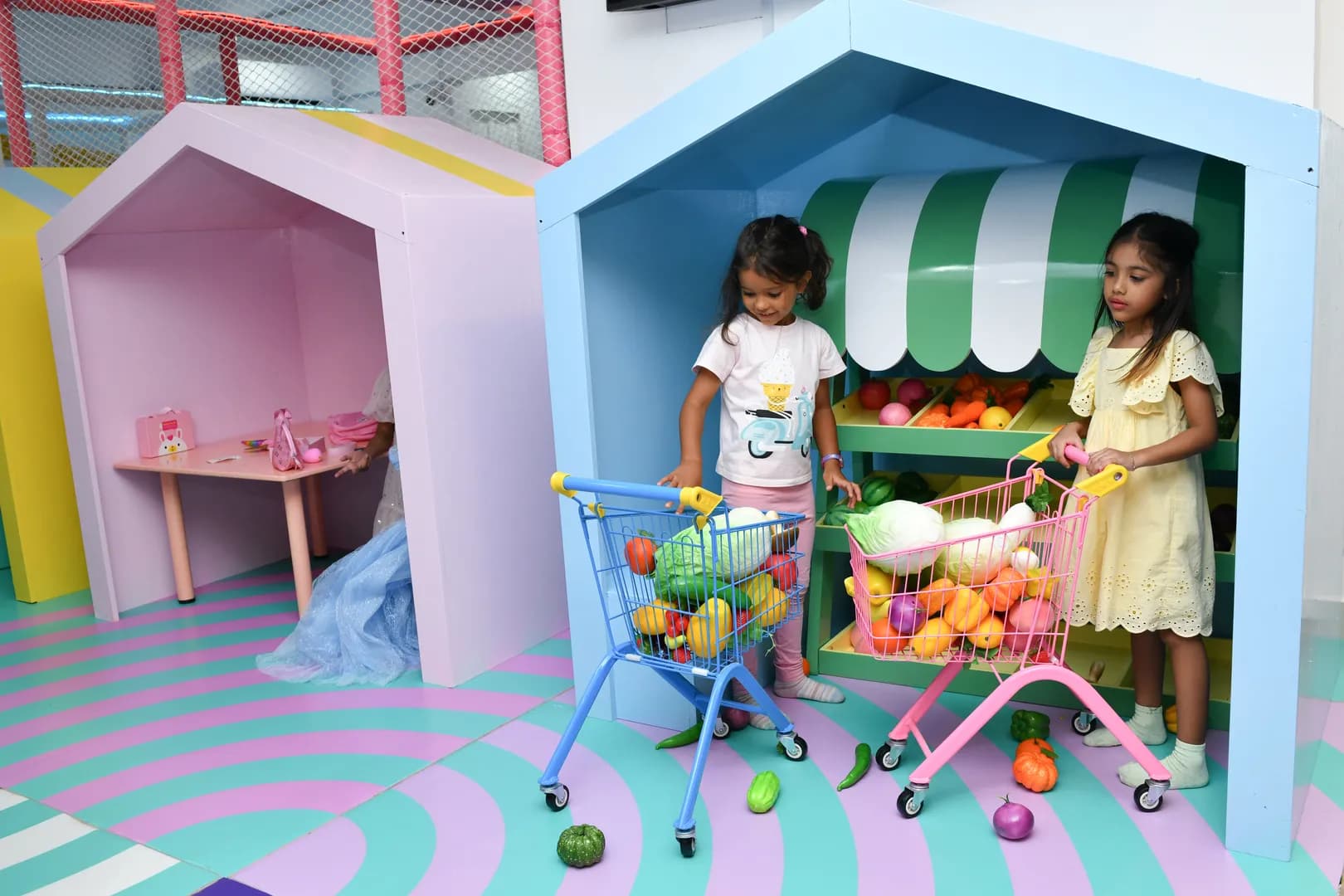 Kids role-playing as chefs in the pretend kitchen at Ooyoo Playcenter